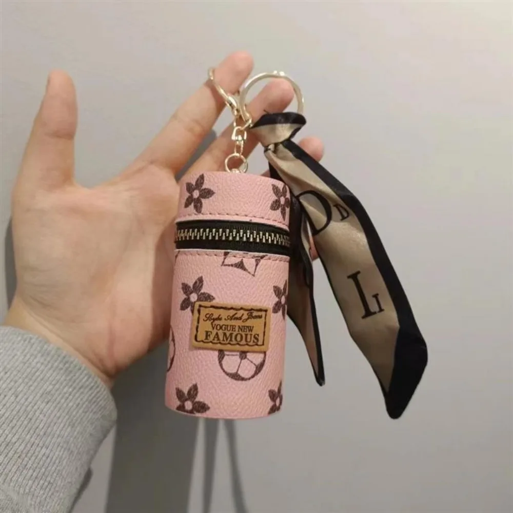 Monogram Keychain Leather - กระเป๋าใส่ลิปสติกทรงกระบอกพิมพ์ลายดอกไม้สีชมพูพร้อมซิปสีเงิน กระเป๋าเก็บเหรียญและหูฟังพร้อมพวงกุญแจโลหะและผ้าพันคอไหมพิมพ์ลายตัวอักษร กระเป๋าใส่กุญแจแบบพกพา